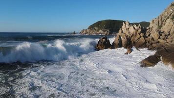 Drohne Aussicht von groß Wellen rollen auf zu das felsig Küste beim Dämmerung video