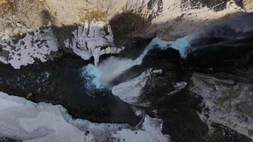 Winter drone view of Karakaya-Su waterfall. A powerful stream bursts out of the rocks. Icicles around the waterfall video