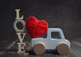 Toy car Valentine Day on wooden background photo