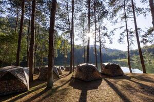 Group of tent for overnight camping with sunrise over the misty mountain and ray of light and campsite of Pang Oung, Mae Hong Son province, Thailand photo