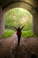 02 of June 2023 - Kazan, Russia - Girl walking through a dark tunnel to the exit. Light at the end of the tunnel. photo