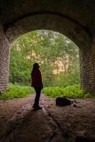 02 of June 2023 - Kazan, Russia - Girl walking through a dark tunnel to the exit. Light at the end of the tunnel. photo