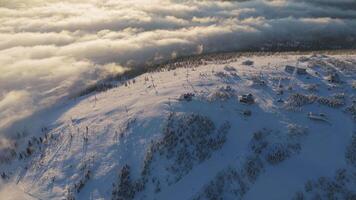 Aerial. Beautiful low clouds float in the valley illuminated by the setting sun video