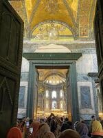 17 of April 2023 - Istanbul, Turkey - Interior decoration of Hagia Sofia, beautiful chandeliers, frescoes and tourists photo