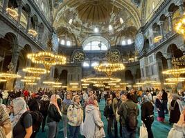 17 of April 2023 - Istanbul, Turkey - Interior decoration of Hagia Sofia, beautiful chandeliers, frescoes and tourists photo