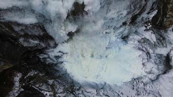 Aerial. a frozen waterfall and icicles hanging from the rocks. video