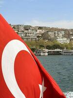 turco bandera revoloteando en el viento con Estanbul y el dorado cuerno puente en el fondo, Turquía foto