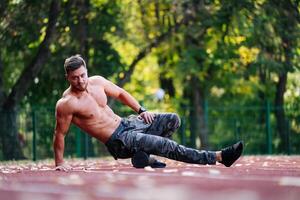 hombre disfrutando un relajante día en el parque. un sin camisa hombre tendido en el suelo en un parque foto