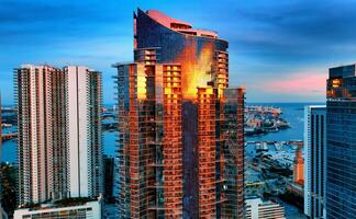 Aerial View of Miami Skyline With Tall Buildings and a Crane. An aerial view of the Miami skyline showcasing tall buildings and a crane in the background. photo