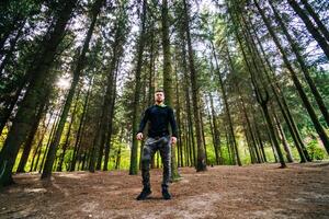 hombre en pie majestuosamente en el corazón de naturaleza. un hombre en pie en el medio de un bosque foto