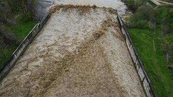 Aerial. a spillway with a powerful flow of rainwater and a fountain of spray video