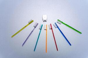 vistoso cepillos de dientes arreglado en un circular formación. un grupo de diferente de colores cepillos de dientes arreglado en un circulo foto