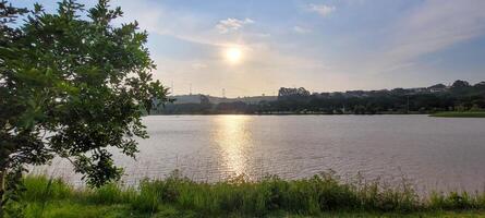 boy playing in a lake in a park in the late afternoon with the sunset in the background photo