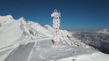 Aerial. cell tower covered with frost on top of a mountain ridge video