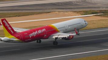 PHUKET, THAILAND - FEBRUARY 13, 2023. Airbus A321-211, HS-VKH of VietJet Air landing, touching down and braking at Phuket airport, side view. Cinematic shot of flight arrival. Spoilers up video