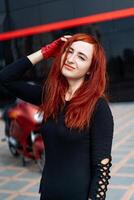 un mujer con rojo pelo posando para un imagen foto