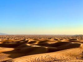 the desert is full of sand dunes and blue sky photo