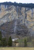 un pueblo y un montaña con un cascada foto