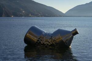 a large statue of bottle in the water photo