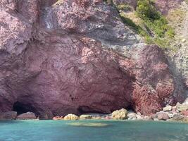 a cave with a large rock formation in the water photo