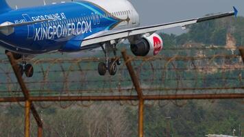 Phuket, Tailandia - gennaio 31, 2023. airbus a320-214, hs-abx di airasia , kingpower.com livrea approdo, toccante giù e frenata a Phuket aeroporto, posteriore Visualizza, attraverso il recinto video