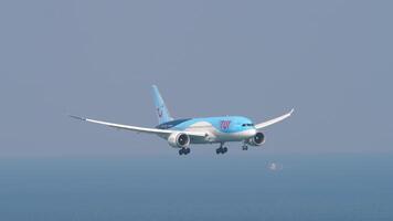 Phuket, Thaïlande - février 22, 2023. métrage de Boeing 787 dreamliner, g-tuih de tui est approchant atterrissage à phuket international aéroport. avion est en volant plus de bleu mer video