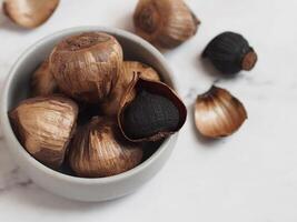 Aged black garlic, healthy food eating with high antioxidants. photo