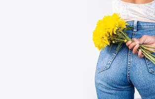 Anonymous woman holding flowers behind her back. photo