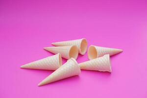 Empty crispy waffle ice cream cones isolated on pink background. Concept, part of pattern of ice creams in cone shape. Snack and dessert. copy space for text. photo