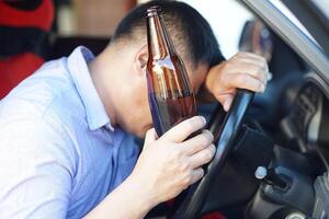 borracho hombre sostiene cerveza botella en coche. concepto , Campaña para no lo hagas conducir, no lo hagas bebida alcohol ese lata porque coche accidente y ilegal. peligroso conducción cuando borracho. foto