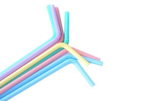 Colorful plastic drinking straws tubes for juice and cocktails, white background. Concept, single use equipment for drinking, but can use for diy crafts for decoration. photo