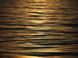 golden sun rays reflection on the sea at sunset photo