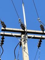 electric pole with power lines and wires on a background of blue sky photo