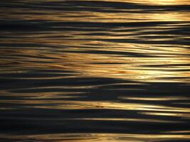 golden sun rays reflection on the sea at sunset photo