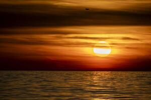 golden sun rays reflection on the sea at sunset photo