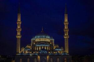 Night view of The Yeni Mosque, New Mosque or Mosque of the Valide Sultan, Istanbul, Turkey photo