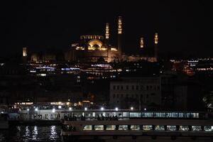 Suleymaniye Mosque Ottoman imperial in Istanbul, Turkey. It is the largest mosque in the city. Night view from Galata Bridge photo