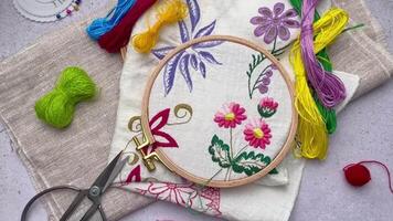 The process of hand embroidering a napkin with colored threads on white fabric. video