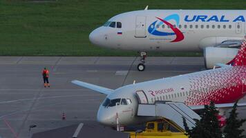 SOCHI, RUSSIA, AUGUST 02, 2022 - Airbus A320 of Ural Airlines at Sochi airport. Sukhoi Superjet of Rossiya on the apron at the terminal. Air travel and tourism concept video