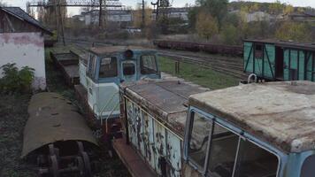 Aerial view of old rusty locomotives and wagons of a narrow gauge railway. Abandoned railway depot. 4K video