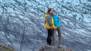 un hombre y un mujer estar en contra el fondo de un glaciar. skaftafell nacional parque. Islandia. 4k video