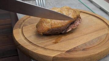 Close-up of juicy freshly cooked duck breast straight off the grill sliced with a fork and knife on a kitchen table video