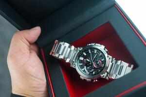 Bangkok, Thailand - February 3, 2024 Hand holdog a box of G-Shock model MTG-B1000D-1ADR. photo