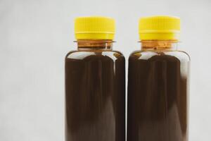 Transparent bottle of chocolate milk or cocoa milk in transparent bottle with yellow lid. photo