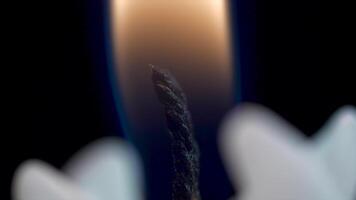 Close up of a candle flame on a black background. White Candle with Dark Background. Burning candles on a dark background with warm light video