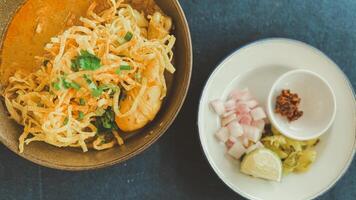 Northern Thai food it called Khao Soi Kai served with pickled mustard greens, shallots and lime photo