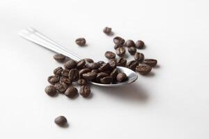 Spoon with coffee beans, macro photo