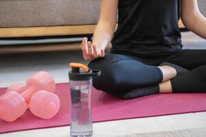 Healthy young woman doing breathing exercises at home, beautiful woman meditating at home with eyes closed, practicing yoga, doing pranayama techniques Mindfulness meditation concept photo
