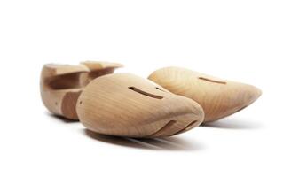 Selective focus of men's wooden shoe stretcher isolated on a white photo