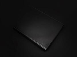 Black leather folder isolated on black background photo